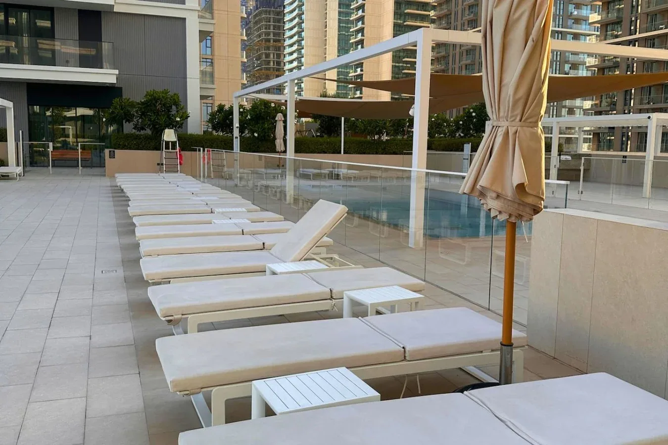 Una terraza de piscina al aire libre con tumbonas junto al agua.