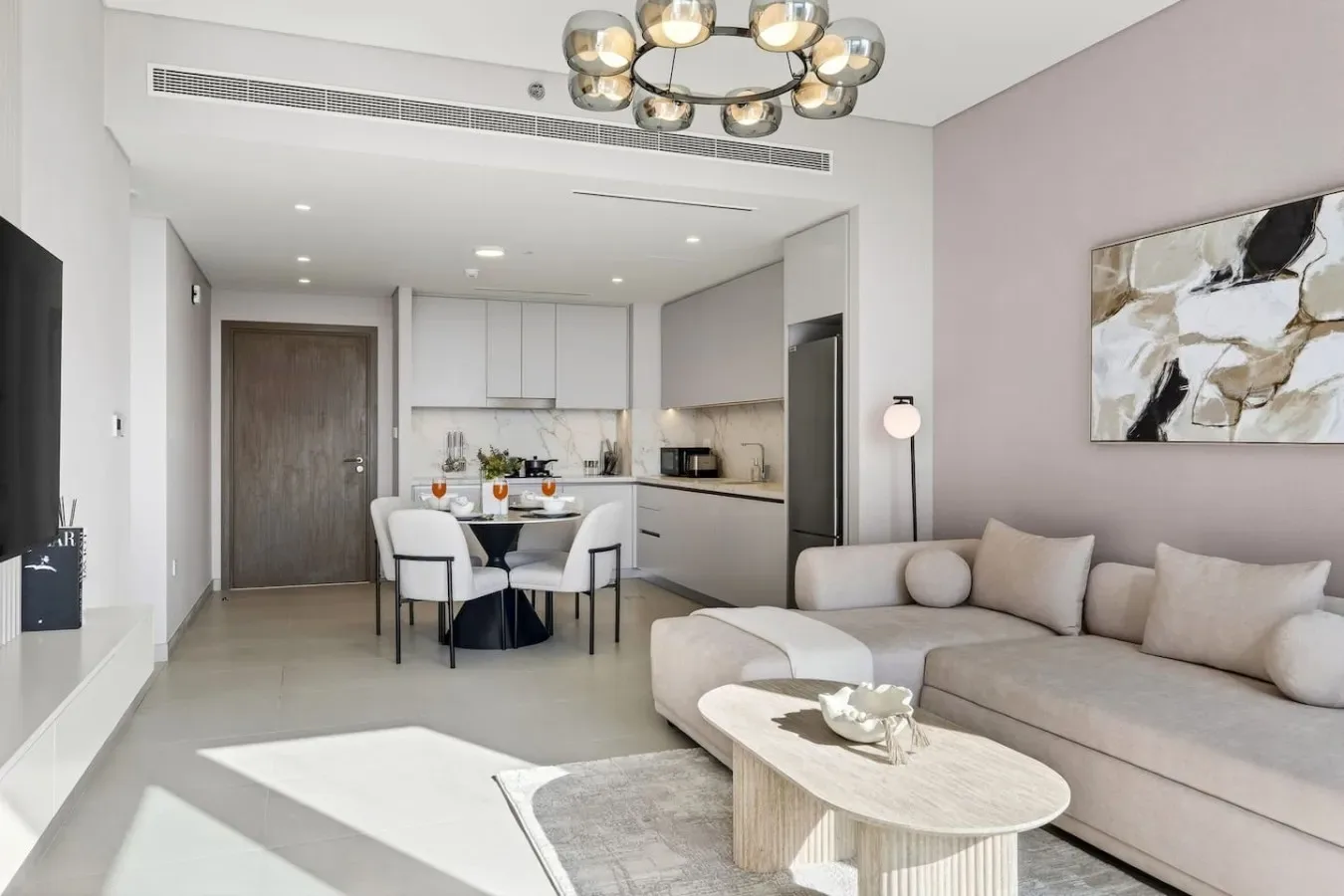 Una luminosa sala-comedor de concepto abierto con sofá seccional y cocina.