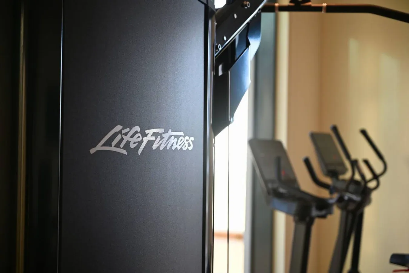Un gimnasio con equipo de ejercicio, incluida una máquina grande y aparatos de cardio.