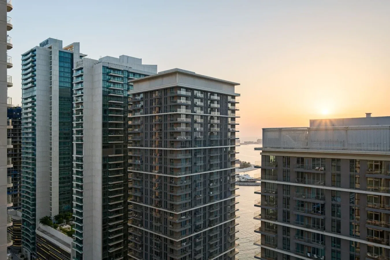 Edificios altos junto al agua bajo la luz del atardecer.