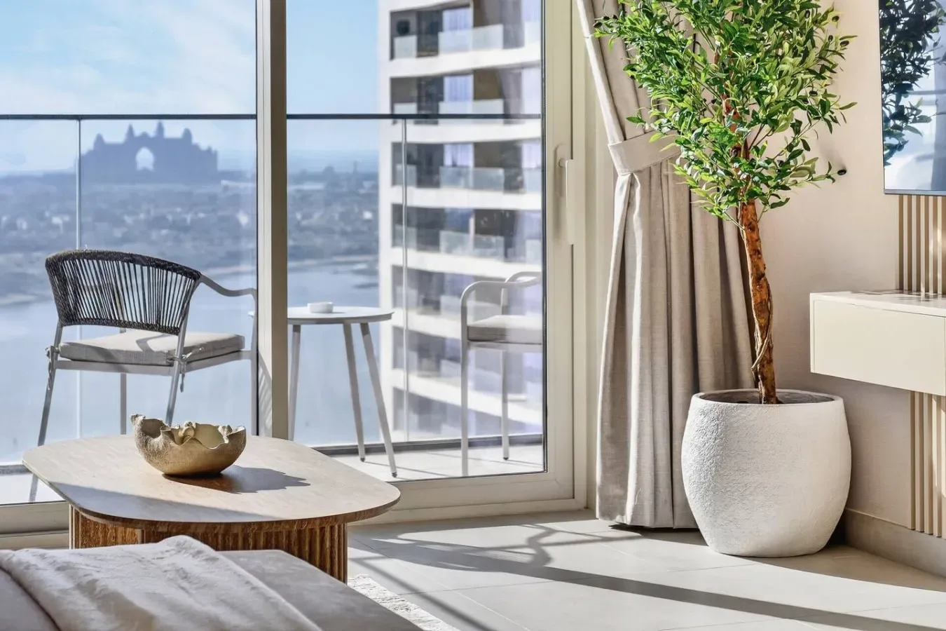 Una luminosa sala de estar da a un balcón con asientos y vistas de la ciudad.