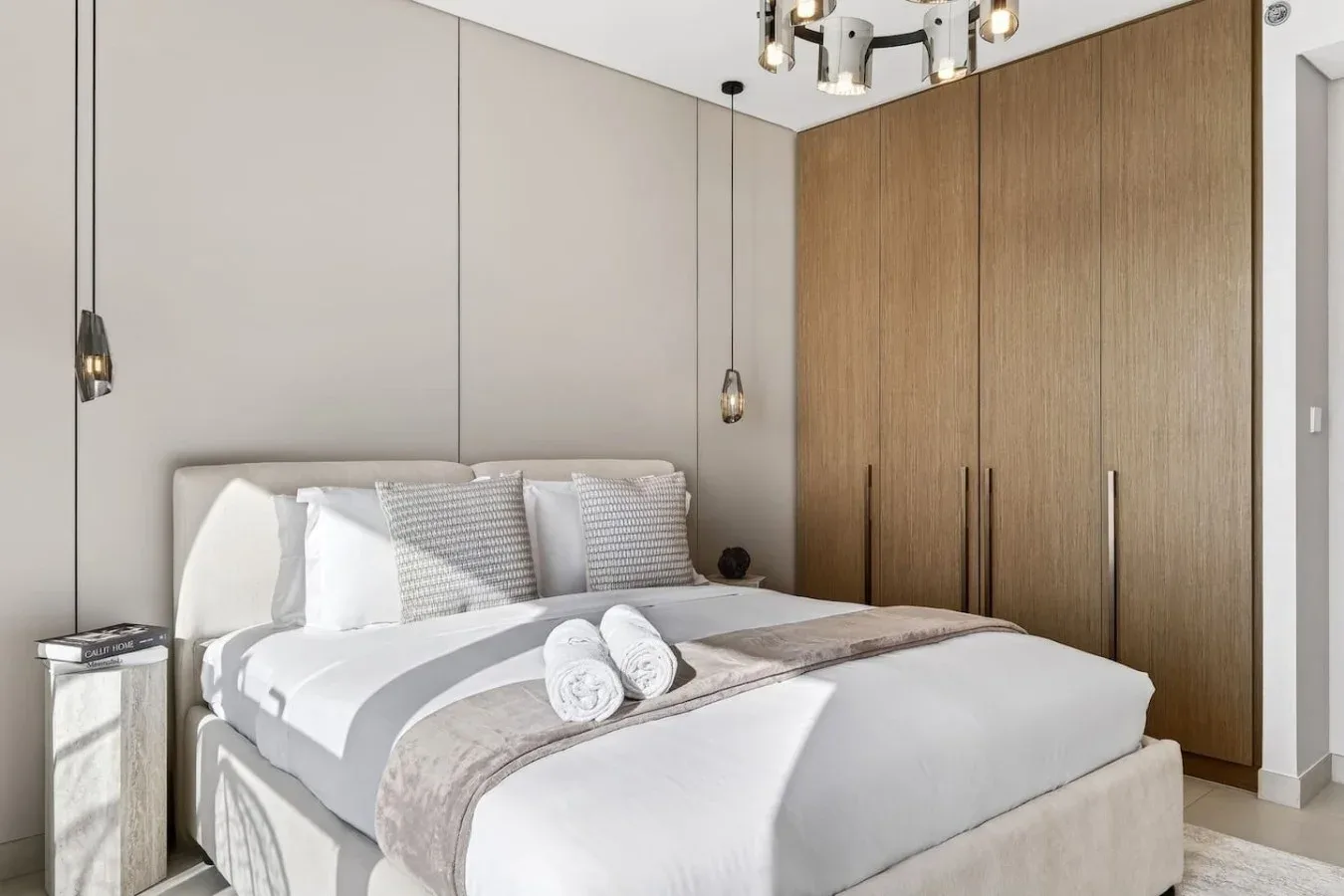 Un dormitorio con una cama bien hecha y toallas dobladas.