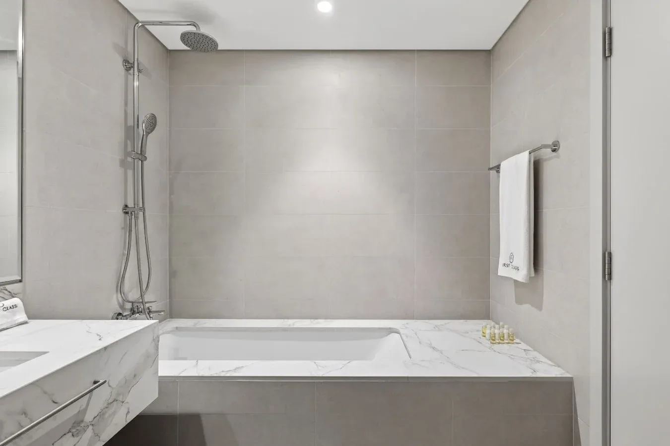 Un baño con bañera, ducha y una toalla colgada en la pared.