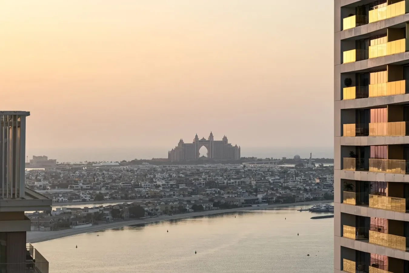 El horizonte de la ciudad se ve sobre una amplia vía de agua al atardecer, entre edificios altos.
