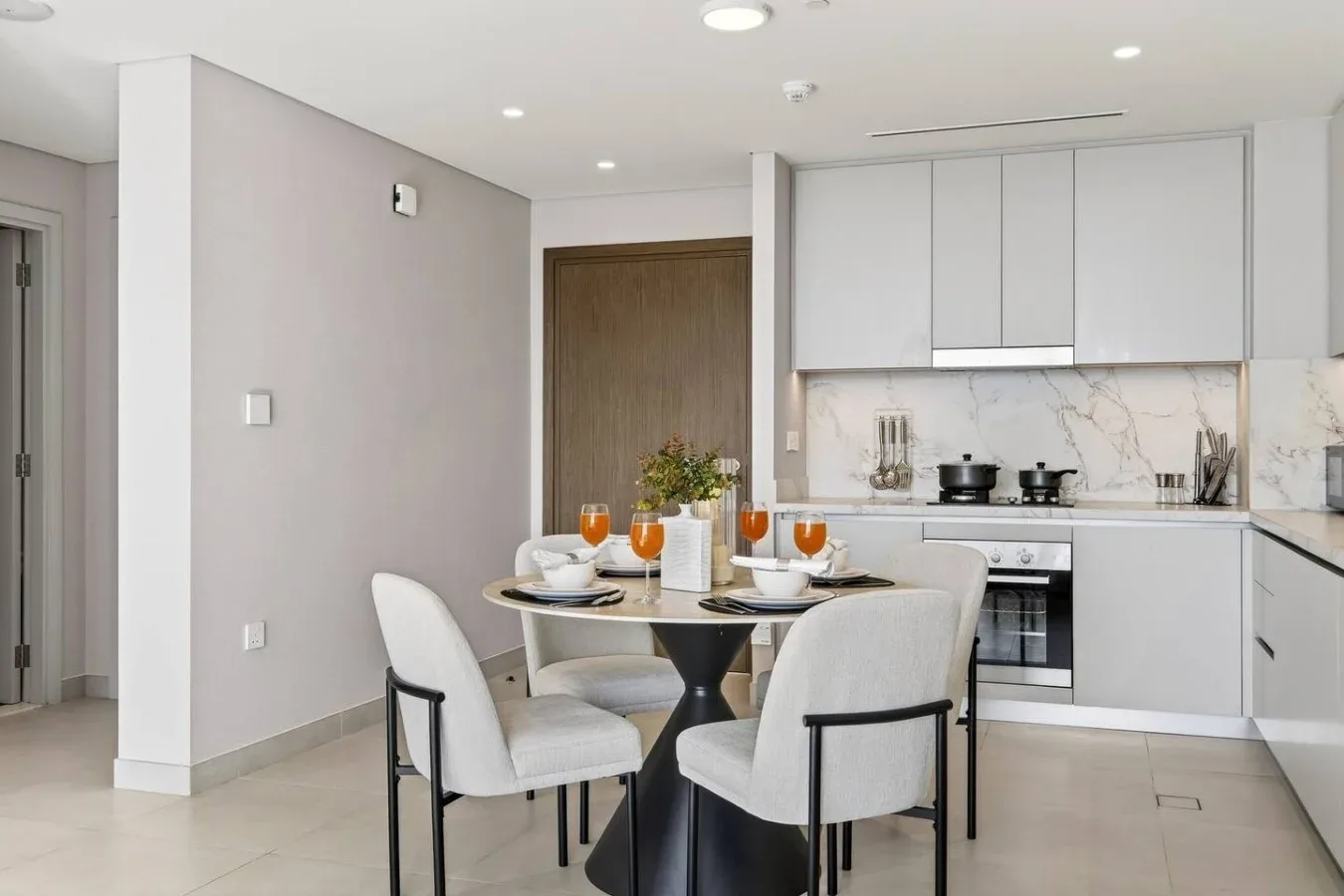 Un comedor con mesa y sillas junto a una cocina moderna.