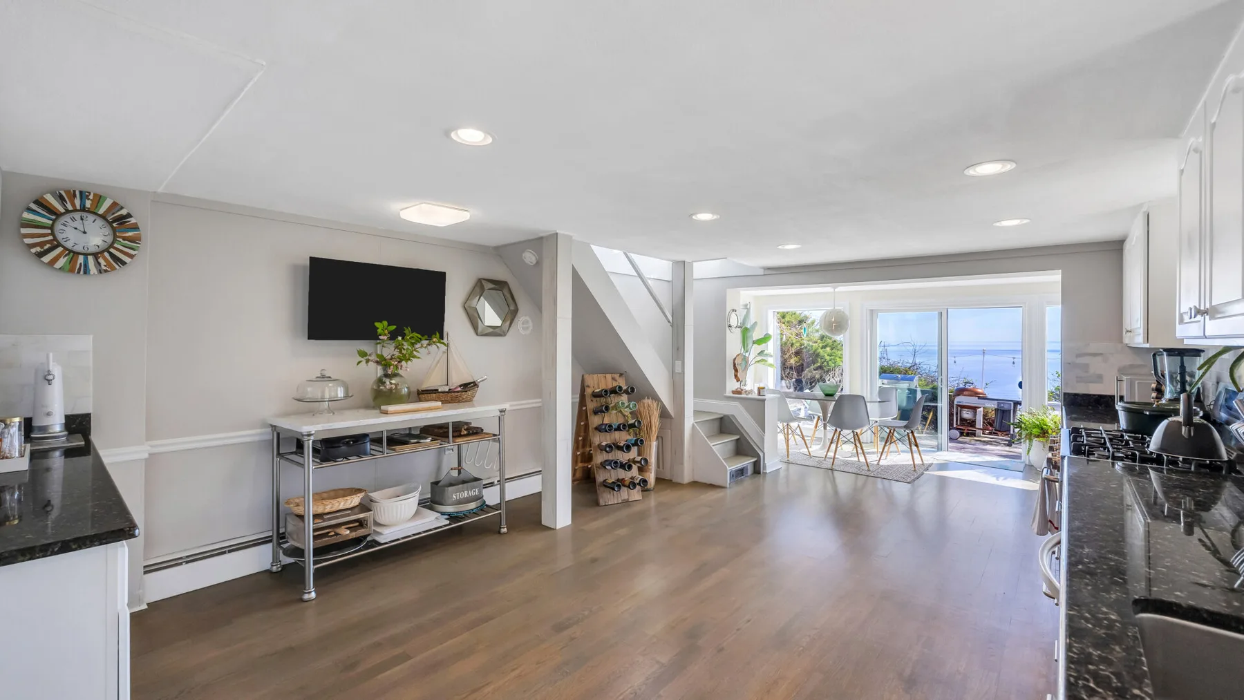 Una luminosa cocina-comedor de planta abierta con una escalera y puertas corredizas de vidrio.