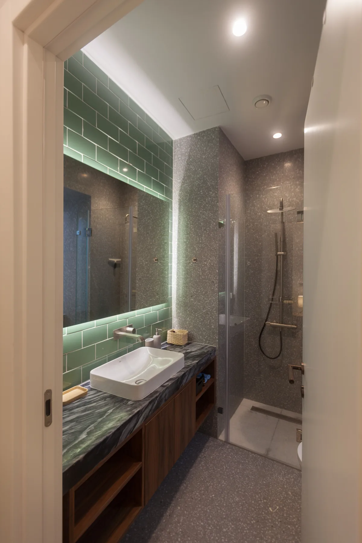 Un baño con lavabo y una ducha con mampara de vidrio.