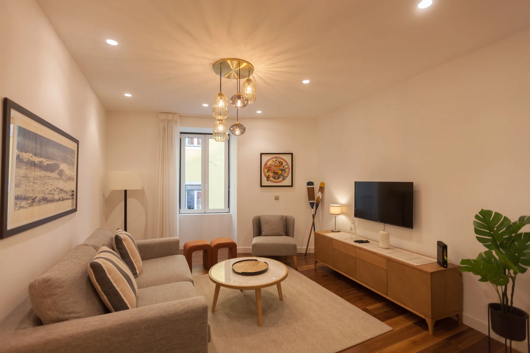 Sala de estar con asientos, una mesa de centro y un televisor.