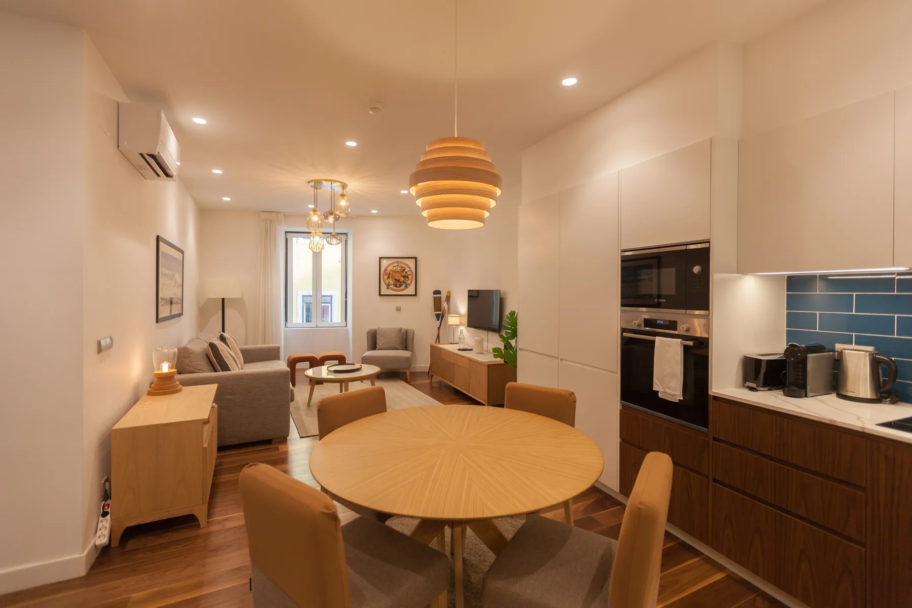 Una sala de estar y comedor diáfana con una mesa redonda y cocina.