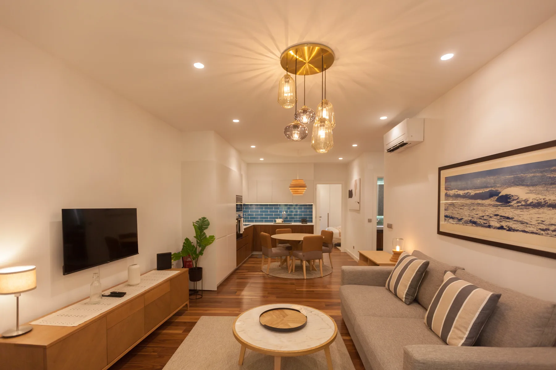 Una sala de estar con sofá, televisor y comedor.
