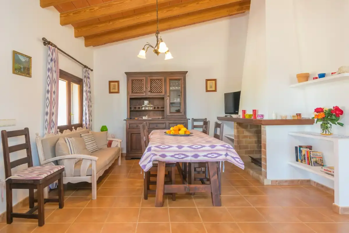 Un comedor y sala de estar con una mesa de madera, asientos y una chimenea.