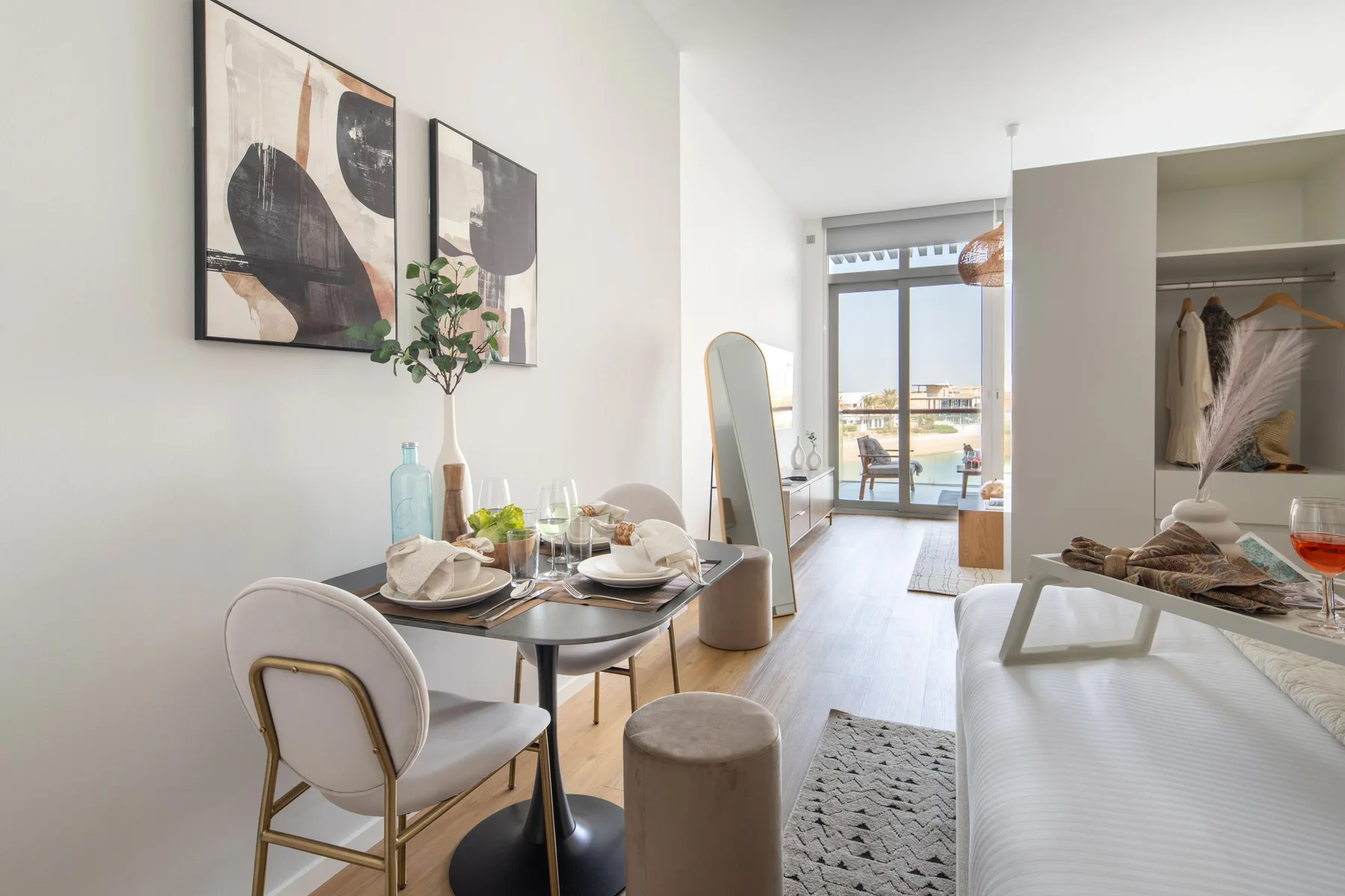 A bright dining and living area with a table set beside large windows.