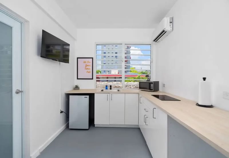 Cocina pequeña con placa de cocción, microondas y nevera pequeña