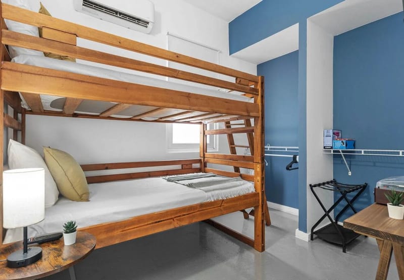 Dormitorio 2 con literas de camas individuales, aire acondicionado y clóset abierto