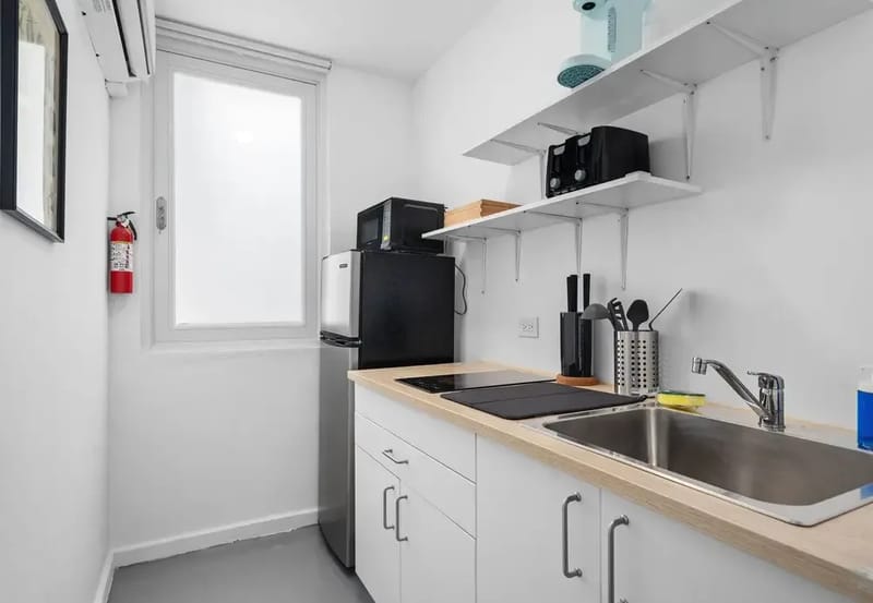 Cocina pequeña con placa de inducción, microondas, mininevera y fregadero