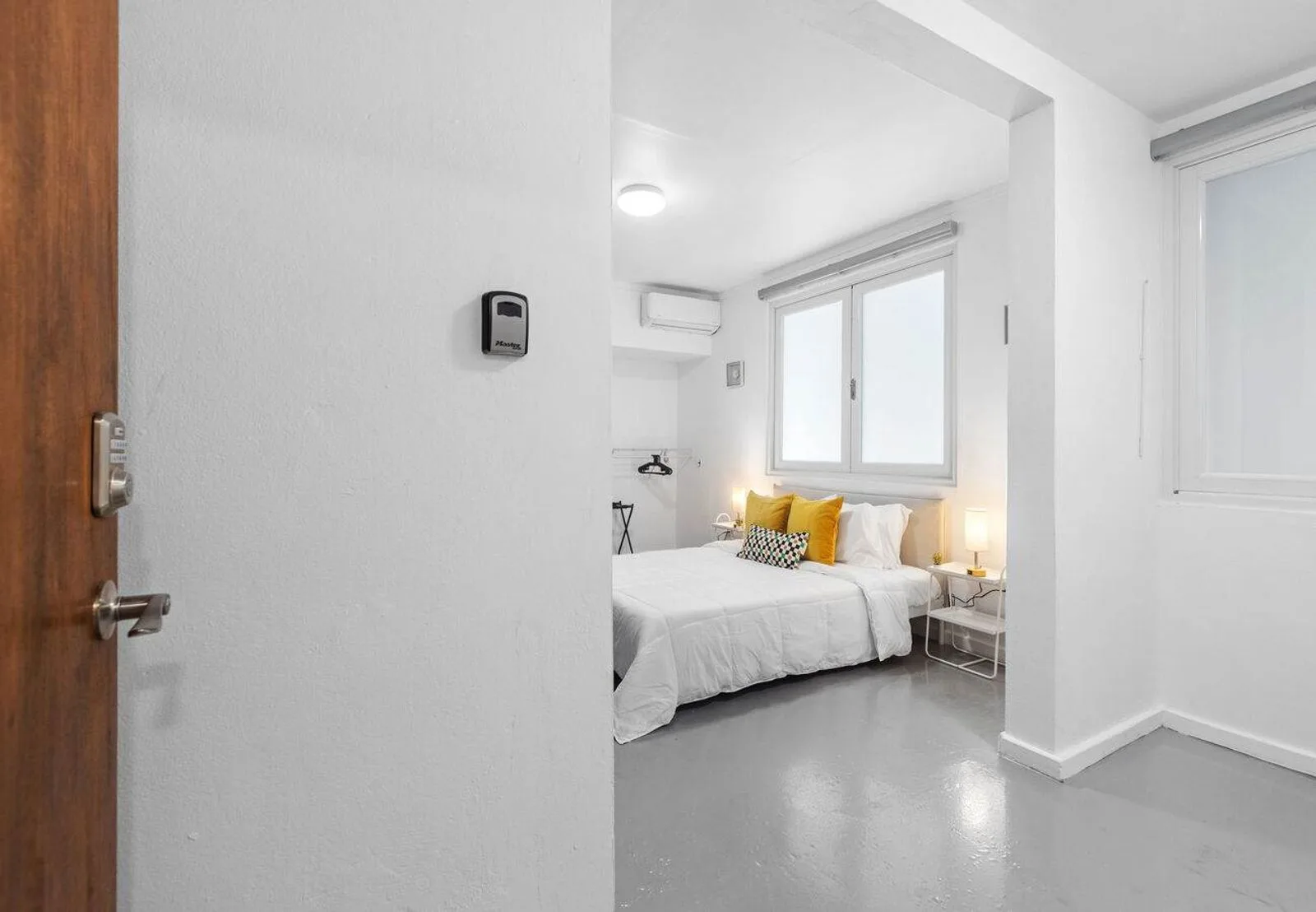Entrada privada que da a un apartamento tipo estudio luminoso y de concepto abierto con acabados modernos.