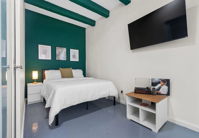 Dormitorio con cama queen, aire acondicionado, televisor inteligente y tocadiscos