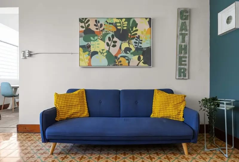 Sofá azul y decoración de pared