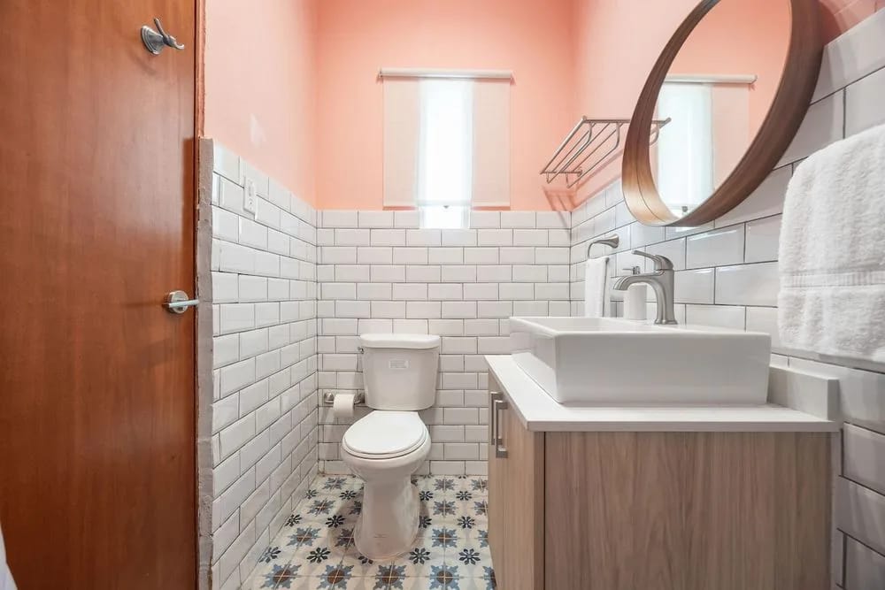 Un baño ordenado y de diseño elegante, con un espejo grande, ideal para arreglarse.