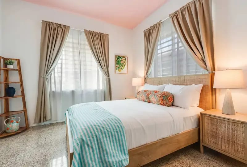 Un dormitorio con una cama queen con ropa de cama blanca.