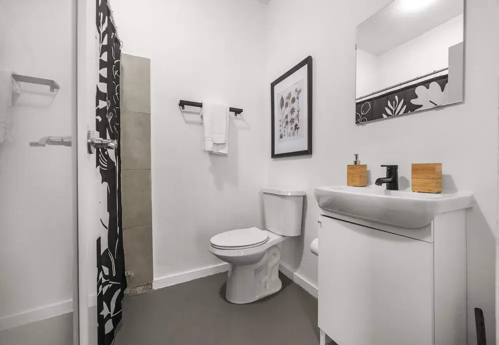 Baño completo con ducha a ras de suelo y artículos de aseo