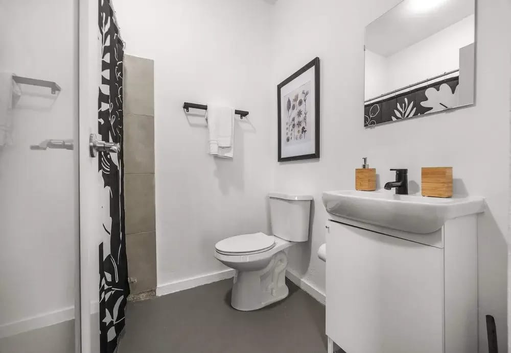 Baño completo con ducha a ras de suelo y artículos de aseo
