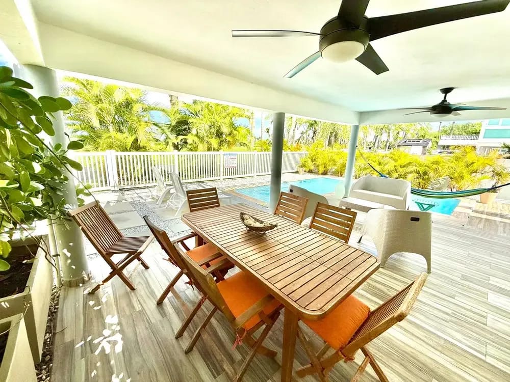 Covered terrace with outdoor dining steps from the private pool