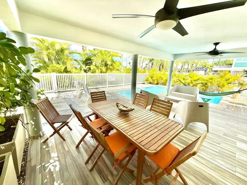Covered terrace with outdoor dining steps from the private pool