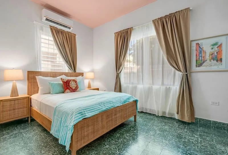 Espacio luminoso y ventilado con ropa de cama impecable e iluminación suave para una noche de descanso.
