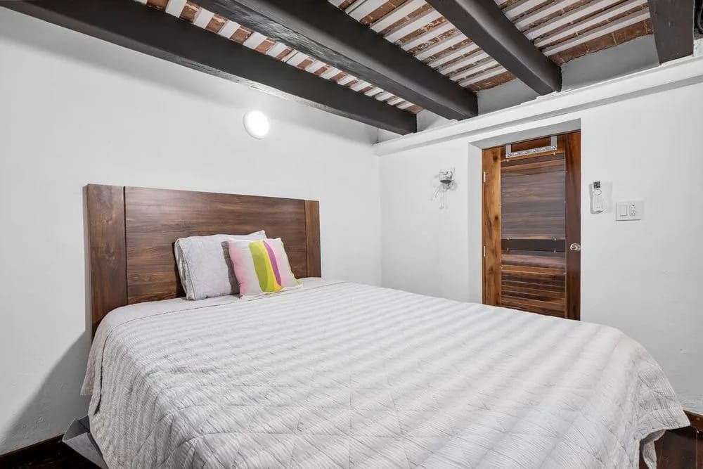 Sueño reparador: cama cómoda con una llamativa cabecera de madera.