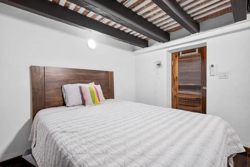 Sueño reparador: cama cómoda con una llamativa cabecera de madera.