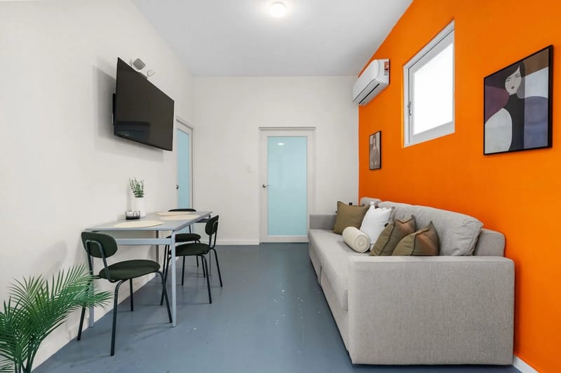 Colorida sala con sofá cama y rincón de comedor