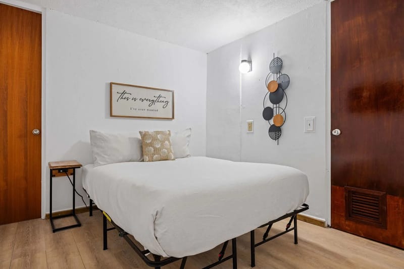 Dormitorio con cama queen, cortinas opacas y aire acondicionado tipo split