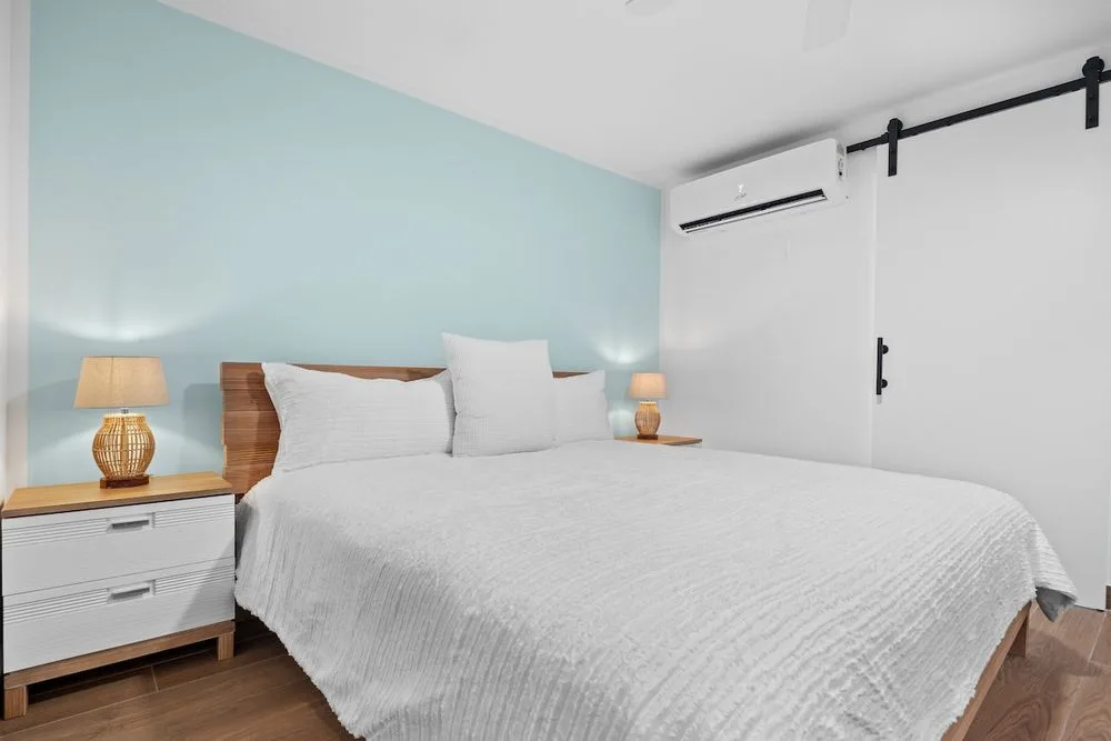 Habitación con cama king, aire acondicionado, puerta corrediza estilo granero y cortinas opacas