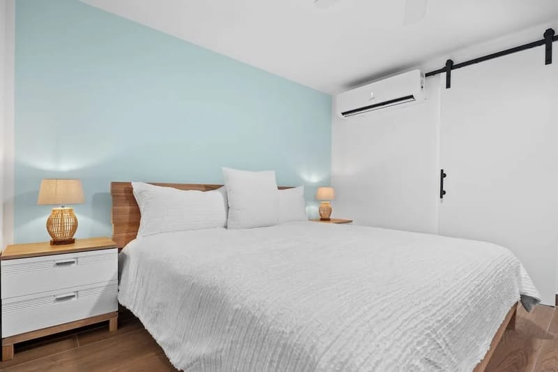 Habitación con cama king, aire acondicionado, puerta corrediza estilo granero y cortinas opacas