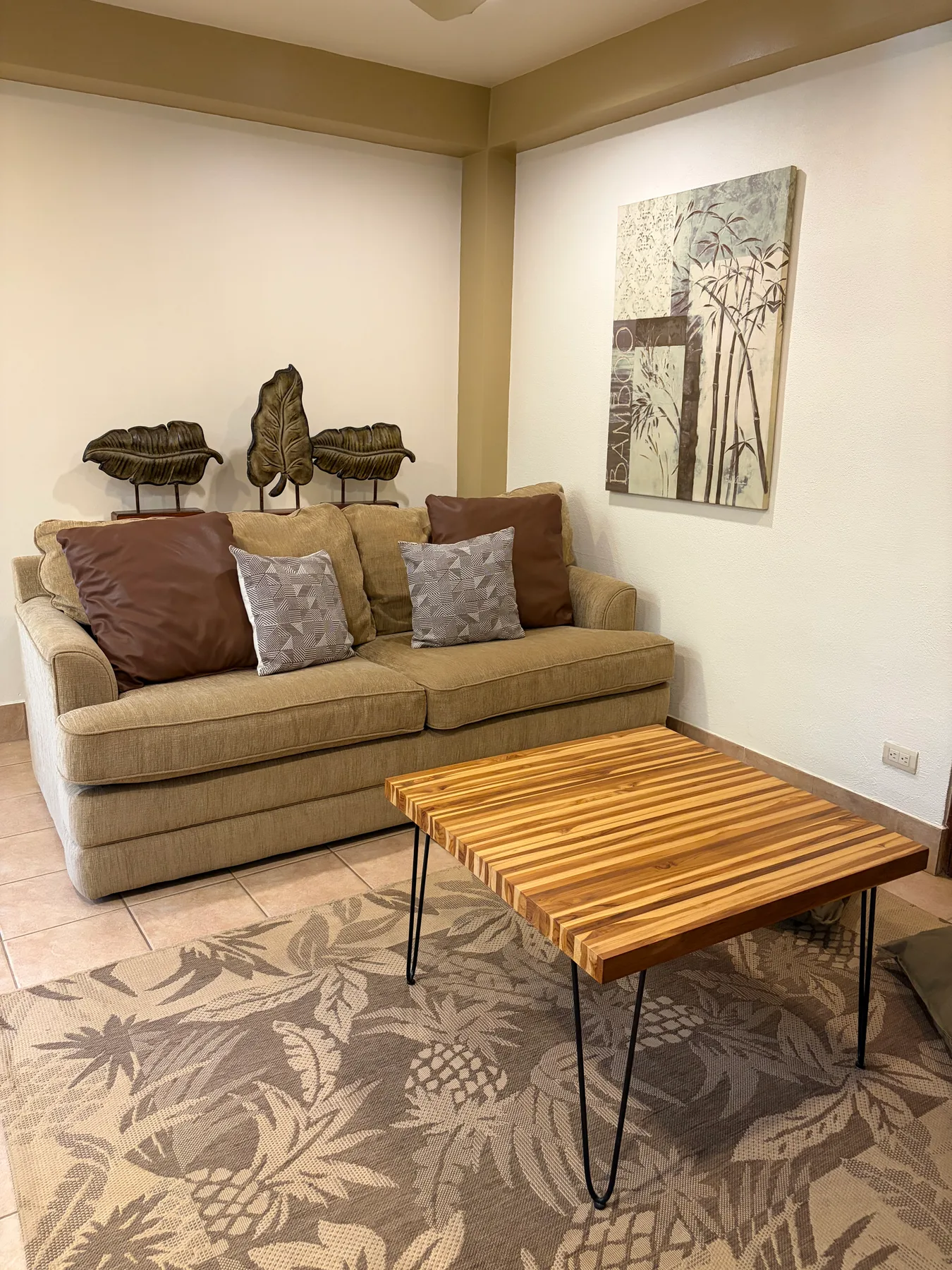 A living room with a sofa and a wooden coffee table.