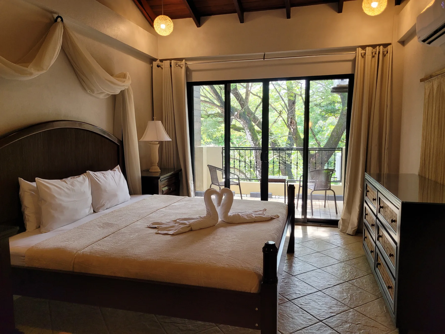 A bedroom with a bed facing sliding glass doors that open onto a balcony.
