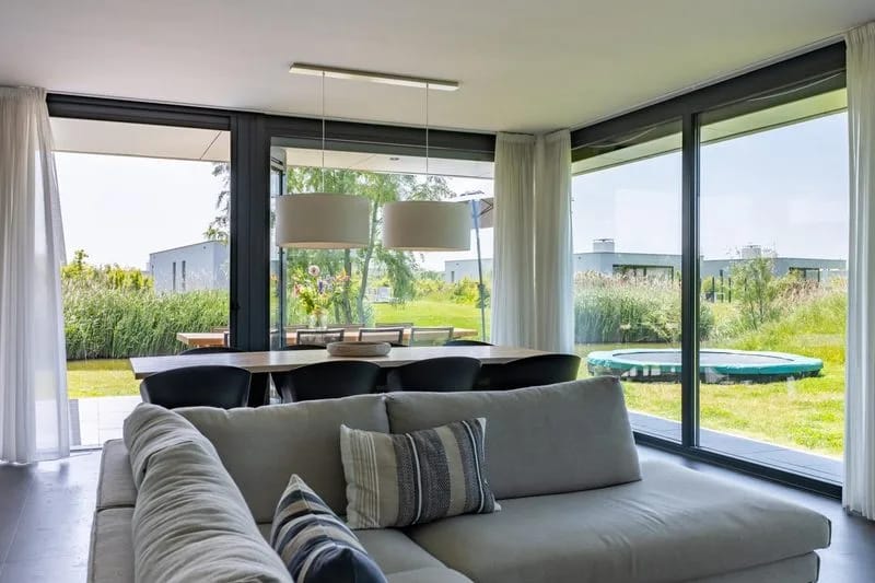 Villa vacacional de lujo adecuada para niños, con cama elástica y situada junto al agua.