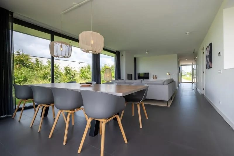Terraza en el jardín con mesa de comedor y tumbonas